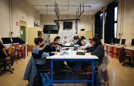 Studenti del Liceo all'interno della classe dedicata al laboratorio multimediale, scrivono su fogli bianchi.